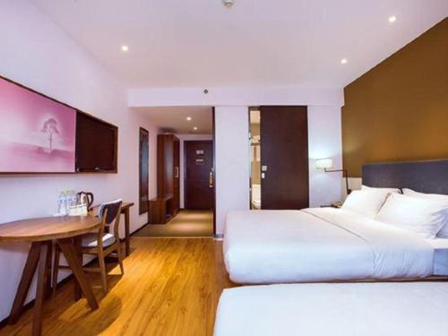 a hotel room with two beds and a table at JTOUR Inn Guilin Two Rivers and Four Lakes Walmart in Guilin