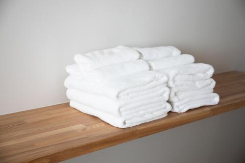 a stack of white towels on a wooden shelf at Tokyo WEST Laffite - Vacation STAY 8298 in Ogikubo