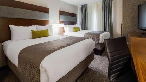 a hotel room with two beds and a television at Best Western Plus Boston Hotel in Boston