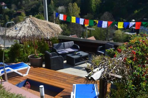 a patio with a wooden deck with chairs and a umbrella at Ausflugsziele Und Wanderidylle Bei Ferieneinrichtungen Haus Am Stein, Haus 2 in Königstein an der Elbe