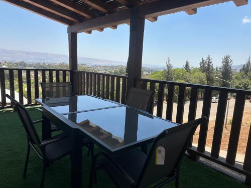 a table and chairs on a balcony with a view at בית יפה-casa Bella in Qiryat Shemona