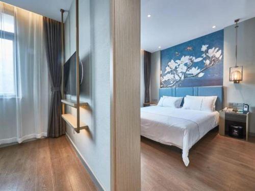 a bedroom with a bed and a painting on the wall at Magnotel Business Shanghai Minhang Wujing East China Normal University in Shanghai