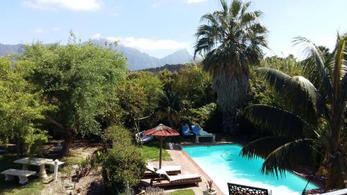 a swimming pool in a resort with mountains in the background at Constantia Lazy River in Cape Town
