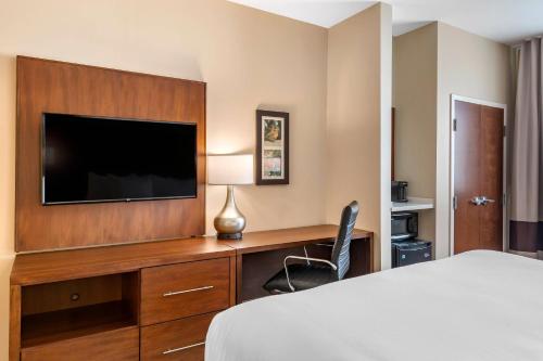 a hotel room with a bed and a flat screen tv at Comfort Inn & Suites in City in the Village of Clarkson