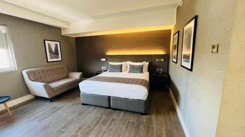 a hotel room with a bed and a couch at Radisson Hotel Curico in Curicó