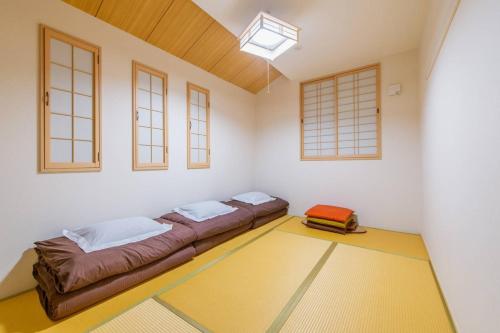 ein Zimmer mit zwei Betten in einem Zimmer mit Fenstern in der Unterkunft Nishikujo 1-16-18 - Vacation STAY 86170 in Osaka