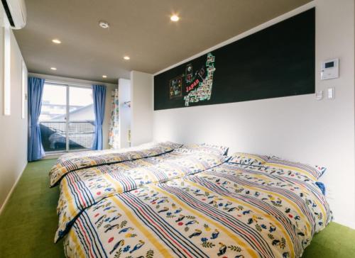 a bedroom with a bed with a colorful comforter at Room 301 - Vacation STAY 86501 in Fukuoka