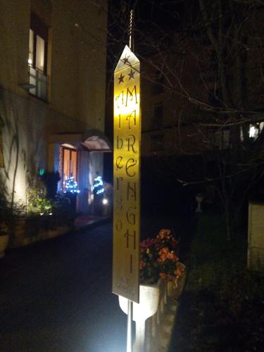 a sign is lit up on a street at night at Albergo Marenghi in Tabiano