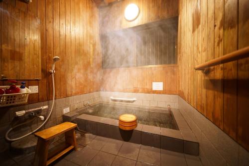 a bathroom with a tub with a toilet in it at Yufuin Kurokiya - Vacation STAY 85694 in Yufuin