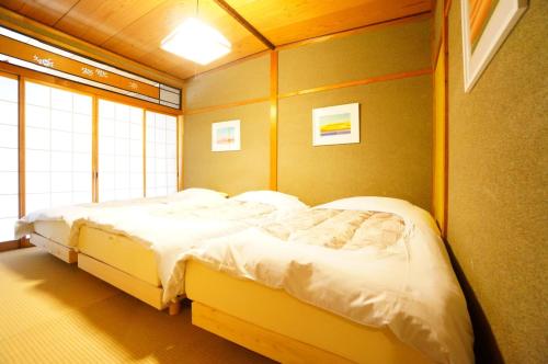 高山Takayama - House - Vacation STAY 85997的一间带窗户的房间里有两张床的卧室