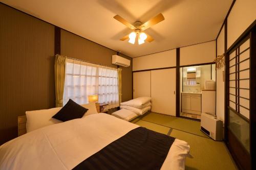a bedroom with a bed and a ceiling fan at SHAKUNAGE-BEKKAN - Vacation STAY 85762 in Yufuin