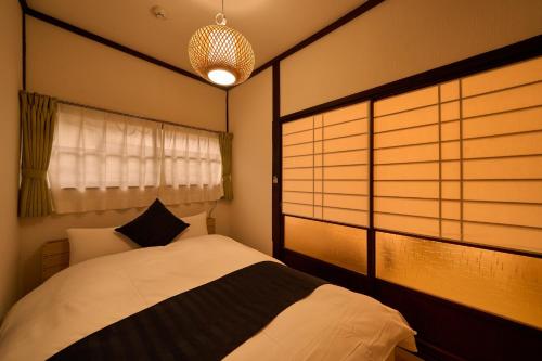 a bedroom with a white bed and a window at SHAKUNAGE-BEKKAN - Vacation STAY 85762 in Yufuin