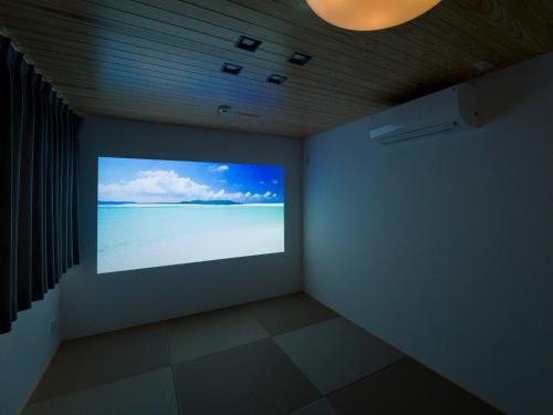 a room with a projection screen of the ocean at Rakuten STAY HOUSE Amakusa 102 in Kami Amakusa