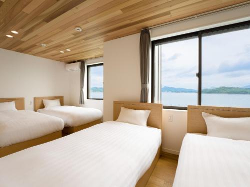 two beds in a room with a large window at Rakuten STAY HOUSE Amakusa 103 in Kami Amakusa