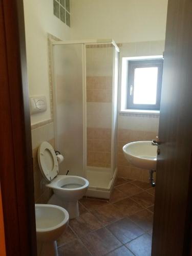 een badkamer met 2 wastafels, een toilet en een douche bij Il Borghetto Antico in Cuccaro Vetere