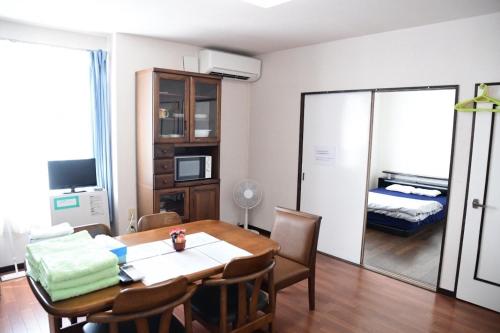 a dining room with a table and a bedroom at Ark City Asahikawa - Vacation STAY 8523 in Asahikawa