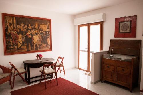フォッローニカにあるDomus Socolatae Apartments&Suitesのテーブル付きのキッチン、壁に絵画