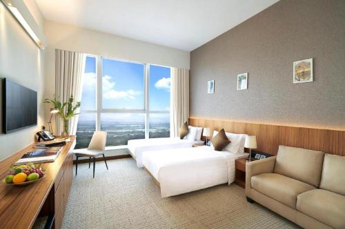 a large hotel room with a bed and a couch at Hotel COZi·Wetland in Hong Kong
