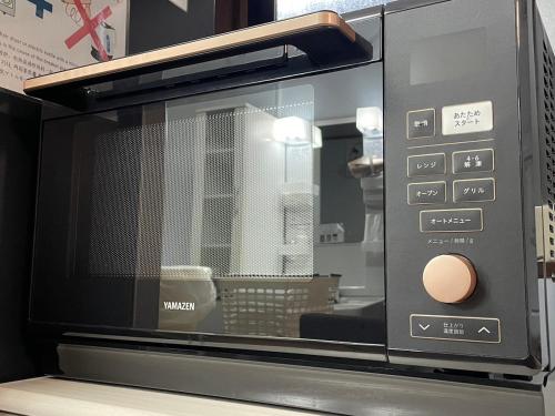 a microwave oven sitting on top of a table at Hana Azusa - Vacation STAY 86863 in Yufuin