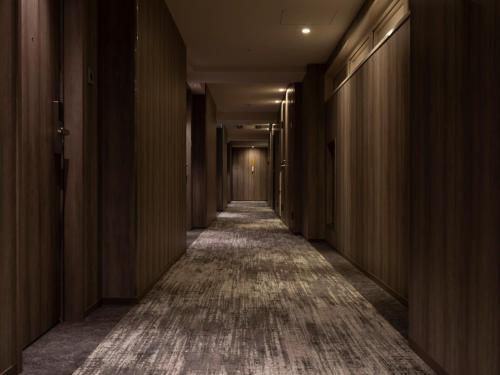 a corridor of a building with a carpeted hallway at Hotel Brighton City Osaka Kitahama in Osaka