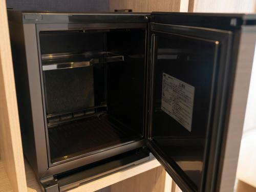 a black refrigerator with a sign on it at Hotel Brighton City Osaka Kitahama in Osaka
