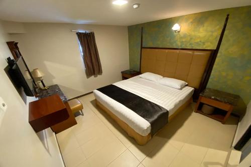 a bedroom with a bed and a painting on the wall at Hotel Bliss Near UTM Skudai 5 Mins Only in Skudai