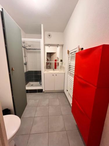 bagno con frigorifero rosso e doccia di Appartement calme proche plage a Lanton