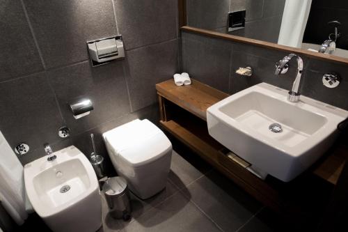 a bathroom with a white toilet and a sink at Avala Resort & Villas in Budva