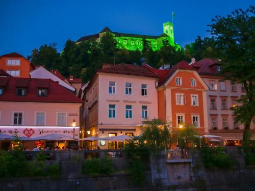 a group of buildings with a green light on a hill at Hotel Mrak in Ljubljana