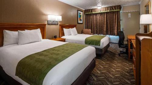 a hotel room with two beds and a desk at Best Western Athens in Athens