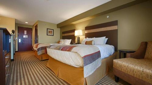 a hotel room with two beds and a couch at Best Western Rama Inn in Ephrata