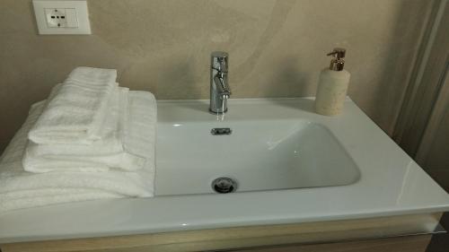 a bathroom sink with white towels and a faucet at Villa Vittoria Apartments in Venice-Lido