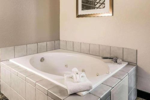 a white bath tub with a towel on it at Suburban Studios Mason Hwy 42 in Mason