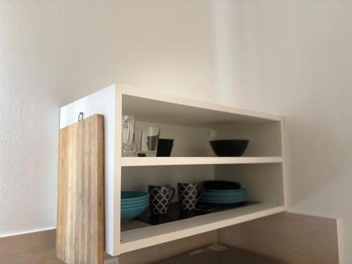 a white cabinet with bowls and plates in it at Hestia Living in Scala