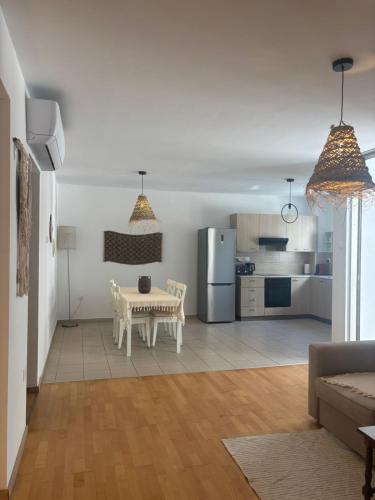a living room with a table and a kitchen at Hestia Living in Scala