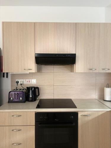 a kitchen with a black stove and wooden cabinets at Hestia Living in Scala