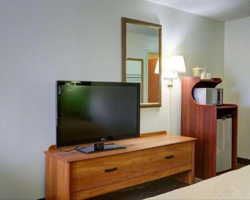 a flat screen tv on a wooden dresser in a room at Quality Inn & Suites Airport in Austin