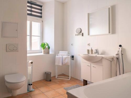 a white bathroom with a toilet and a sink at Maximi Apartments by Rosini - gegenüber Dom & nahe Schloss Merseburg, ideal für Geschäftsreisende, Familien & Longstay in Merseburg