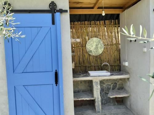 a blue door in a bathroom with a sink at La calma entre naranjos in Melegis