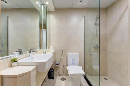 a bathroom with a sink and a toilet and a shower at 151 Residence Jumeirah Gardens in Dubai