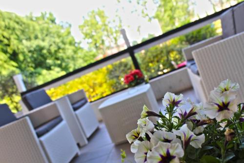 a balcony with white chairs and a vase of flowers at Park Hotel in Castrocaro Terme