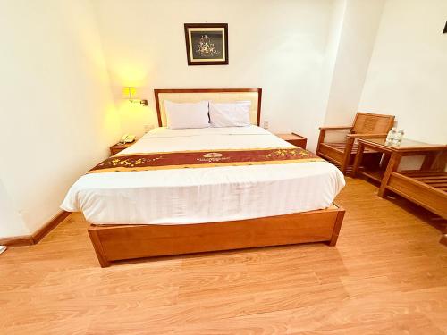 a bedroom with a large bed in a room at Khách sạn Golden Beach Nha Trang in Nha Trang
