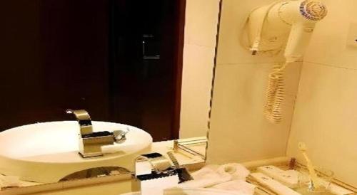 a bathroom with a white sink and a mirror at Chengdu Huadu Times Hotel in Chengdu