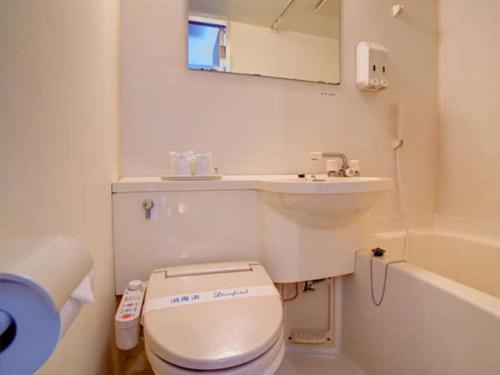 a white bathroom with a toilet and a sink at Okinawa Sunplaza Hotel in Naha
