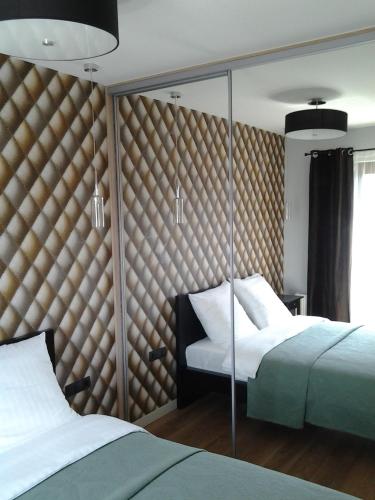 a bedroom with two beds and a wall of mirrors at Garden Corner in Krakow
