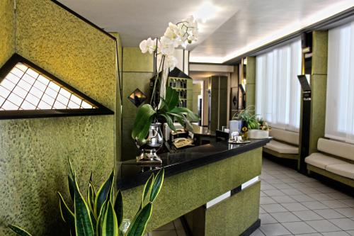 a bathroom with a counter with a vase of flowers at Park Hotel in Castrocaro Terme