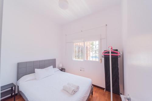 a bedroom with a white bed and a window at Expoholidys- Chalet privado en Castell del Rey in Almería