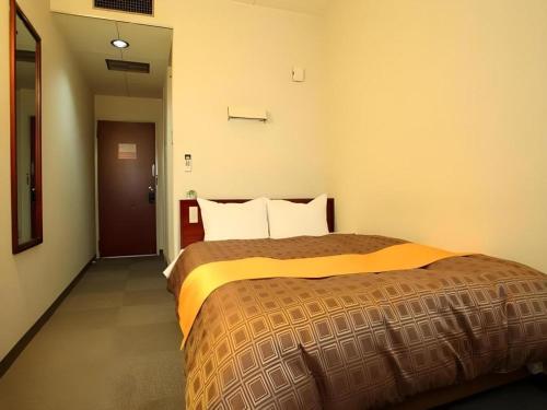 a hotel room with a large bed in a room at Hotel 1-2-3 Kofu Shingen Onsen in Kofu