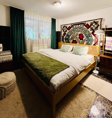 a bedroom with a large bed with a green headboard at Ciumarna Holiday House in Vatra Moldoviţei