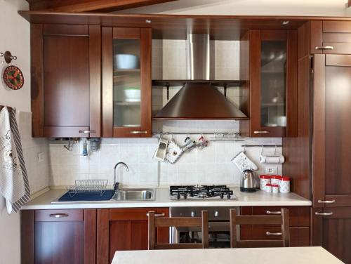 Una cocina con gabinetes de madera y un fregadero. en La Villetta, en Sulzano